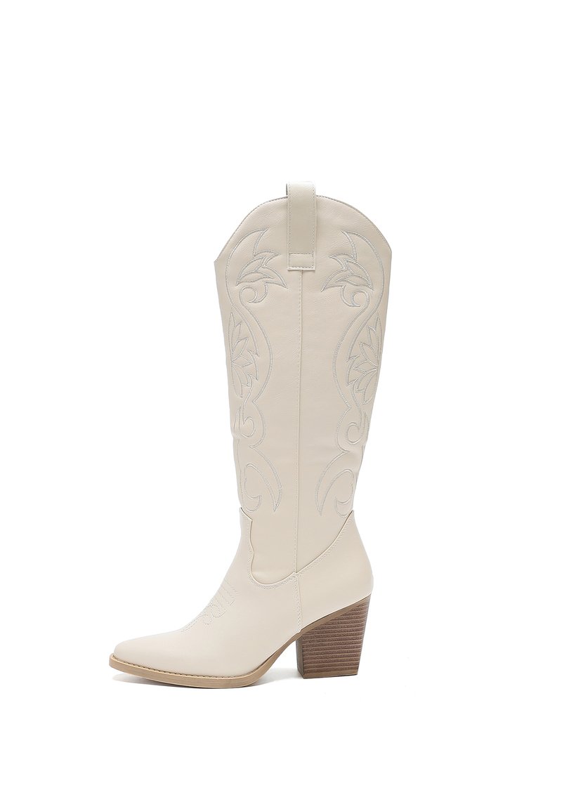 Bota vaquera blanca de cuero con diseños florales bordados, punta afilada, lengüeta y un tacón de madera apilada. Textura suave.