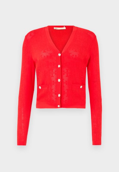 Piros kötött kardigán V-nyakkal, hosszú ujjal és ezüstgombokkal. Két elülső zsebbe és perforált textúrával rendelkezik. Rövidített fazonú.