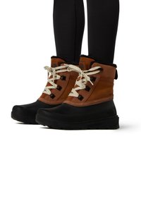 Botas impermeables marrones y negras con suelas de goma texturizada, cordones beige y un forro de piel sintética en un diseño de media caña.
