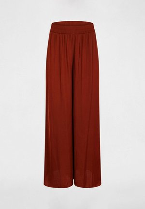 Pantaloni a gamba larga di colore ruggine con vita elasticizzata arricciata, mostrati su sfondo chiaro e uniforme.