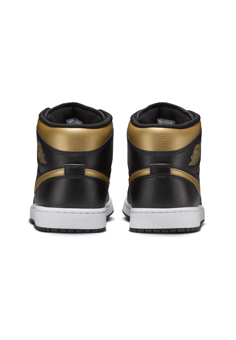 Zwarte leren high-top sneakers met gouden accenten, gevoerde kraag, witte tussenzool en textuurelementen. Heeft een logo aan de zijkant.