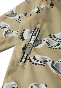 Beige tyg med vita och svarta fågelillustrationer samt en vit plastdragkedja med en silverfärgad draganordning.
