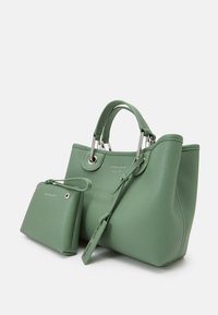 Zielona skórzana torebka z teksturowaną powierzchnią, srebrnymi elementami i dwoma uchwytami. Dołączona jest mała pasująca saszetka przymocowana paskiem.
