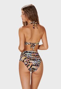 Hög midja bikini med flerfärgade, abstrakta mönster på en svart bakgrund. Materialet är slätt med knytning i nacken och en smickrande sk ärning.