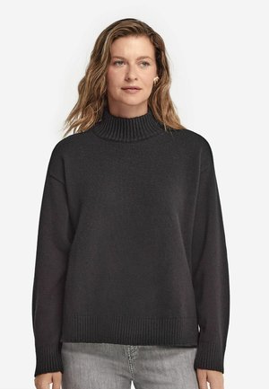 Mörkgrå polotröja i mjukt tyg med ribbad krage och muddar, med en lös passform och en något texturerad yta.