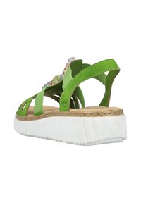 Zielone sandały z wieloma paskami, korkową wkładką i białą, żebrowaną podeszwą. Posiadają dekoracyjne akcenty na cholewce.