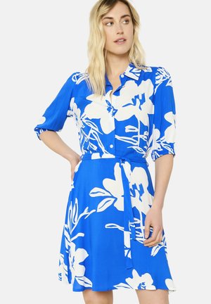 Blue dress with white floral pattern, button-down front, short sleeves, and belt at the waist. Smooth fabric and knee-length design.