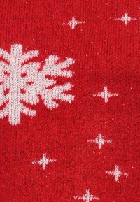 Tissu tricoté rouge avec des motifs de flocons de neige blancs et de petits accents d'étoiles blanches, avec une surface texturée et un léger éclat.