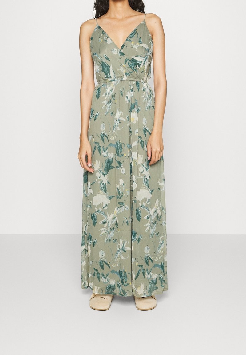 Robe maxi en tissu vert olive avec un motif floral, dotée d'un décolleté en V et de fines bretelles. Texture douce et design fluide.