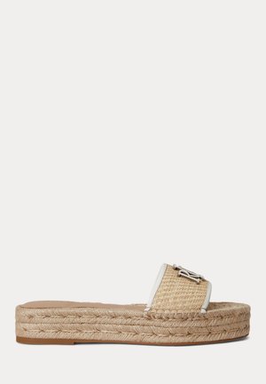 Sandale plate style espadrille à enfiler avec semelle en jute tissé et large bride beige texturée ornée d'un détail logo décoratif argenté.
