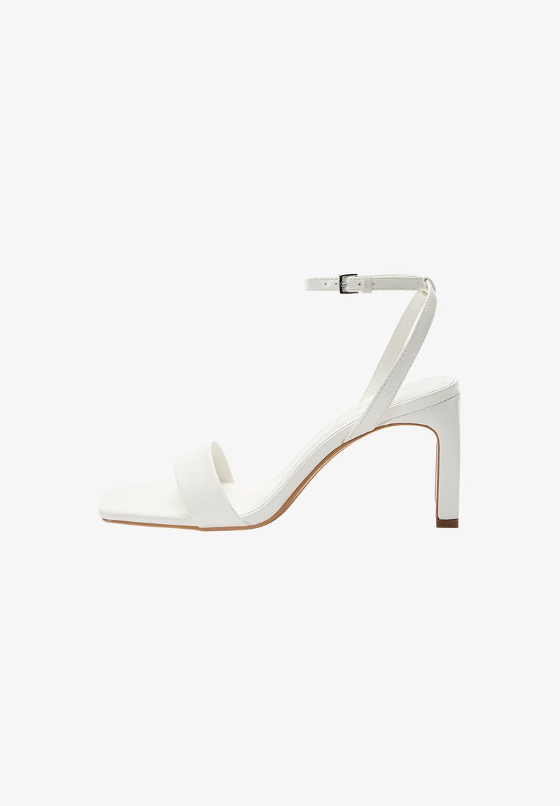 Sandale blanche à talons hauts en matériau lisse, avec une bride de cheville, un bout carré et un talon bloc fin.
