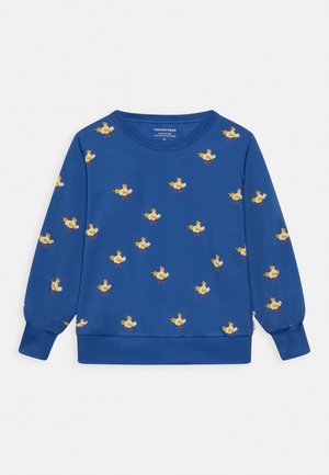 Sweat-shirt enfant à manches longues bleu avec un motif répétitif de petits oiseaux de dessin animé jaunes et blancs, ludiques, portant des chaussures rouges et un chapeau.