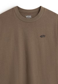 Brown cotton T-shirt with a crew neckline and loose fit. Features a small black Vans logo on the left chest area. Soft texture.