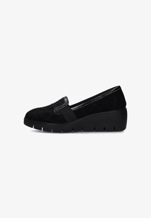 Scarpe slip-on in suede nero con tomaia texturizzata, dettagli in elastico e suola a zeppa spessa con un motivo scanalato.