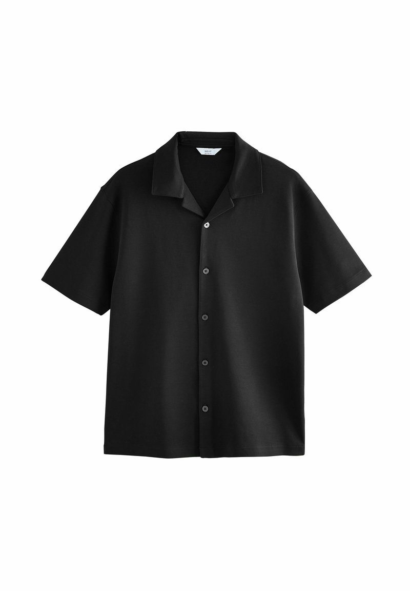 Maglietta nera a maniche corte con chiusura frontale a bottoni, texture morbida e colletto strutturato. Presenta sei bottoni neri lungo la patta.