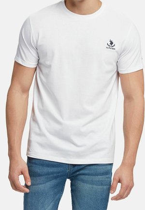 Camiseta blanca de algodón con cuello redondo, mangas cortas y un logo azul marino en el lado izquierdo del pecho. La tela es suave y sin textura.