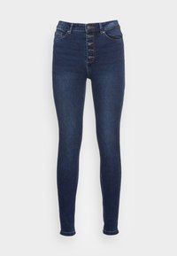 Tumman siniset farkut, tiukka malli ja korkealle istuva vyötärö, jossa on viisi nappia edessä, klassinen viiden taskun muotoilu ja hillitty tammikuviointi.