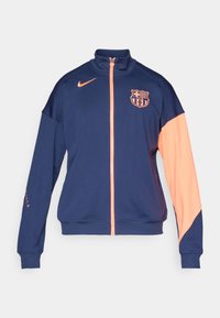 Navy zip-up jacket with orange accents. Features a high collar, elastic cuffs, and a logo on the chest. Made from smooth, lightweight fabric.