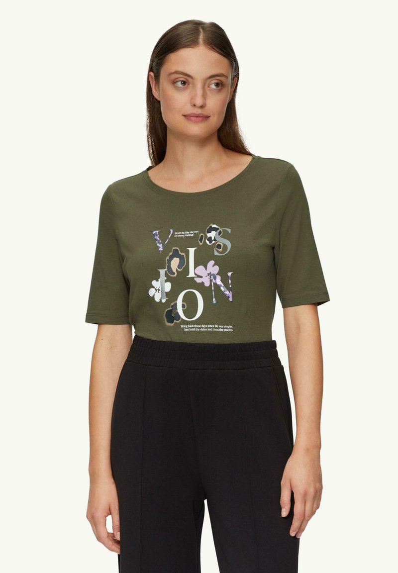 Olijfgroene t-shirt met korte mouwen, ronde halslijn en bloemenprint met tekst, gecombineerd met zwarte, elastische taillebroek.