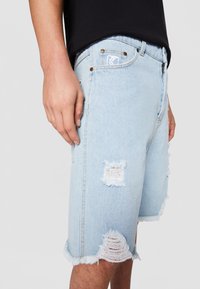 Karl Kani HEAVY DISTRESSED - Džinsa auduma šorti - bleached blue