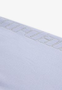 Jasnoniebieska tkanina o teksturowanym wykończeniu, z srebrnym haftowanym napisem wzdłuż krawędzi, prezentująca czysty i nowoczesny design.