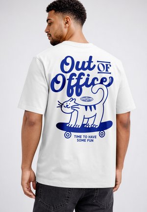 Mann trägt weißes T-Shirt mit blauer Grafik einer Katze auf einem Skateboard und den Texten "Out of Office" und "Time to Have Some Fun."