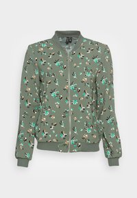 Veste bomber verte avec un motif floral aux accents blancs, noirs et orange. Le matériau est doux, avec une fermeture éclair à l'avant et des poignets côtelés.