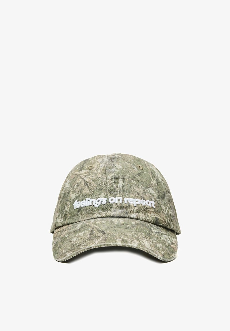 Grüne Baseballkappe mit Tarnmuster, gebogenem Schirm und weißem, gesticktem Text "feelings on repeat" auf dem Vorderpanel.