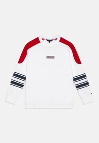 Sweatshirt a maniche lunghe di colore bianco con pannelli rossi sulle spalle, dettagli a righe blu navy sulle maniche e etichetta centrale nera. Materiale in cotone.