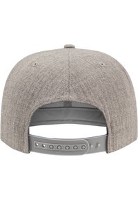 Hallhalli tekstuuriga hall snapback müts, lame äärega ja reguleeritava plastist rihmaga, millel on mitu nupuvajutust taga.