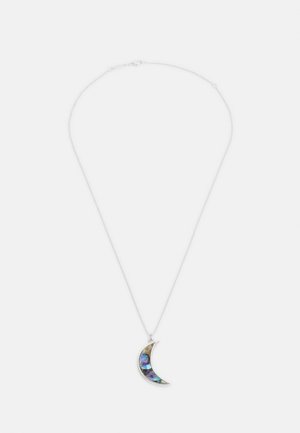 Collier en chaîne argentée avec pendentif en forme de croissant de lune comportant une incrustation irisée bleu et vert sur un fond blanc.
