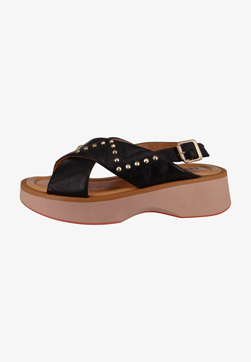 Black leather platform sandals with crisscross straps, gold studs, and a tan footbed. Features a chunky sole with red accents. Buckle closure.