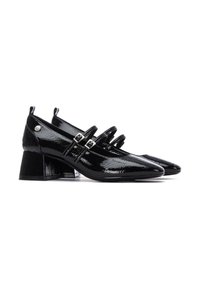 Zapatos de charol negro con punta afilada, que presentan tres tiras en la parte media del pie y un tacón grueso. Incluye detalles en plata.