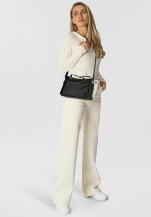 Sac en cuir noir à bandoulière avec un design structuré, doté d'une poignée supérieure et d'une bandoulière réglable, placé sur un fond neutre.