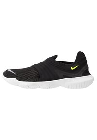 Czarne sportowe buty wsuwane z teksturowaną cholewką, elastycznym paskiem i białą podeszwą. Zawierają mały odblaskowy detal oraz żółty akcent w logo.