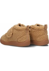 Bruine fleece babyslofjes met een gestructureerde afwerking, zachte voering en tan rubberen zolen. Voorzien van lusjes voor eenvoudig aan- en uittrekken en hebben een ronde vorm.