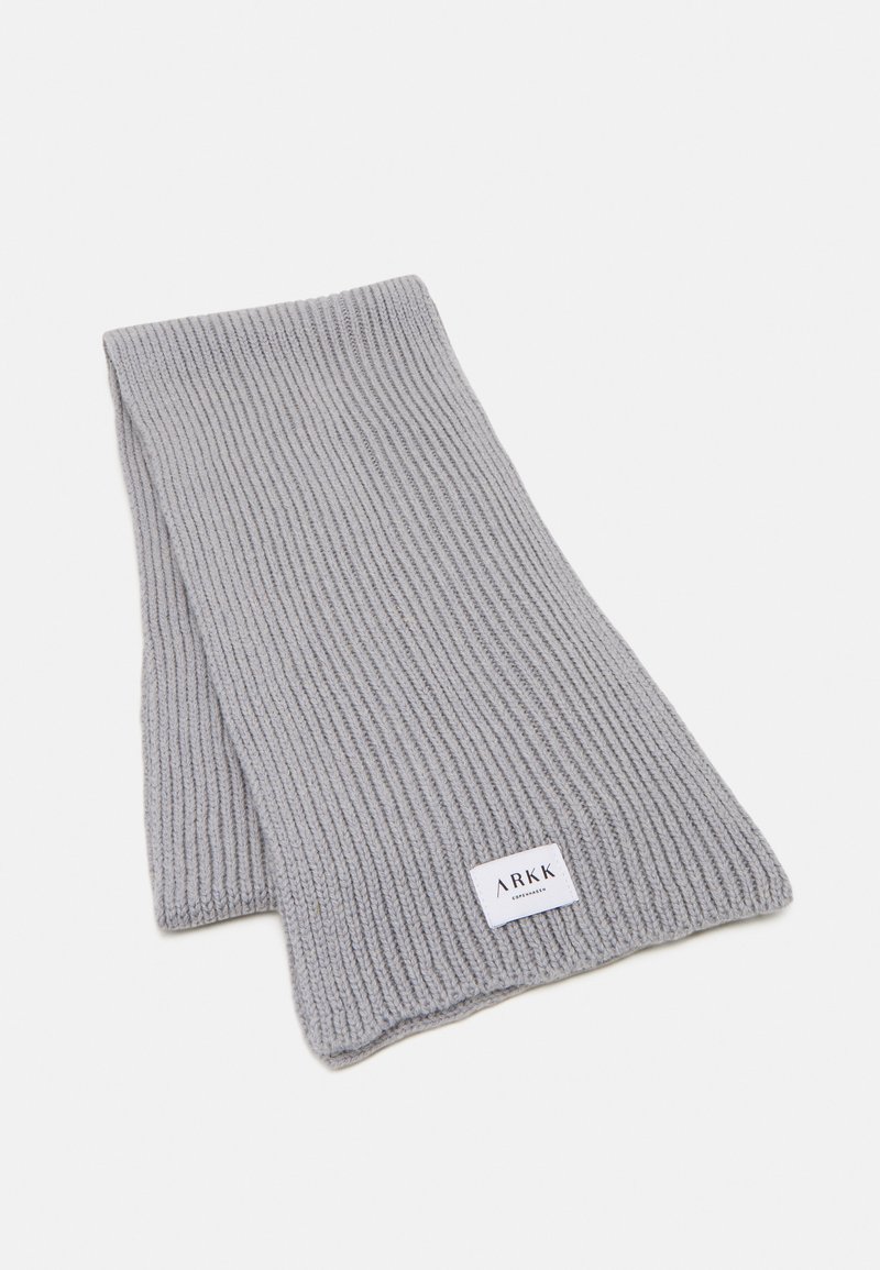 Cachecol cinza de malha canelada com uma textura suave e um etiqueta com o nome da marca "ARKK". Forma retangular; adequado para estilo de envolver.