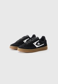Black suede sneakers with white side accents. Features a low-top design, rubber sole, and flat laces. Suitable for casual wear.