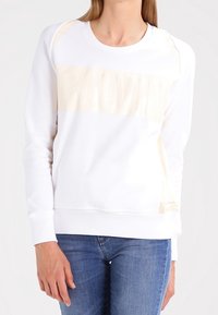 Sudadera blanca con un gran logo tonal "CALVIN" en el frente. Fabricada en tejido suave con cuello redondo y puños acanalados.