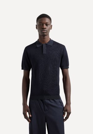 Polo shirt in maglia blu navy con design testurizzato, maniche corte e colletto. Orlo a costine e dettagli del colletto lisci.