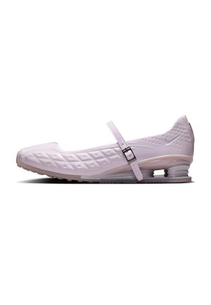 Chaussure Nike Mary Jane blanche avec texture à motif losange, bride réglable et talon bas et rebondissant, vue de côté sur fond blanc.
