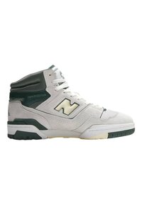 Zapatillas altas en ante y malla blanca y verde oscuro. Presentan cordones gruesos, cuello acolchado y un logo distintivo en el lateral.