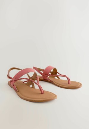 Sandali in suede rosa con cinturini intrecciati, suola piatta color tannato e cinturino alla caviglia con fibbia dorata. Design semplice e punta aperta.