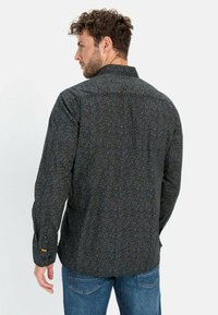 Herreskjorte med lange ærmer i mørkt stof med et flerfarvet blomsterprint. Har en standardkrave og knapmanchetter.