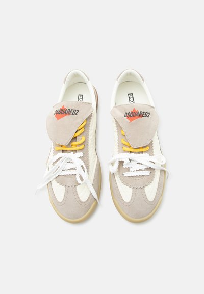 Baskets beiges et blanches avec des lacets blancs et jaunes, des détails en daim et le logo "DSQUARED2" sur les languettes, vues de dessus.