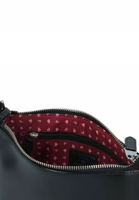 Schwarze Lederhandtasche mit einem Reißverschlussfach. Innenfutter aus kastanienbraunem Stoff mit kleinen rosa Mustern. Sichtbare silberne Reißverschlussbeschläge.