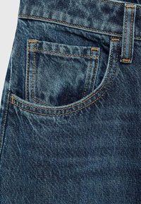 Jean en denim bleu foncé avec une poche avant ornée de coutures orange et un tissu texturé. Le design comporte une forme de poche traditionnelle.