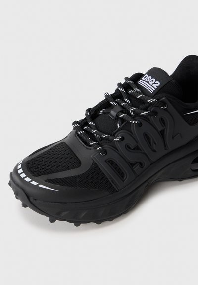 Pantof sportiv negru cu plasă în partea superioară, talpă groasă, șireturi cu model și logo-ul "DSQ2" pe parte și pe limbă.