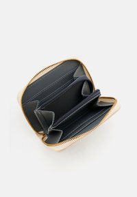 Compact beige wallet with a gold zipper, featuring multiple card slots, a central compartment, and a smooth interior finish.