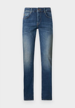 Blaue Slim-Fit-Denim-Jeans mit vorderer Knopf- und Reißverschluss, Verblassung an den Oberschenkeln und klassischem Fünf-Taschen-Design vor weißem Hintergrund.